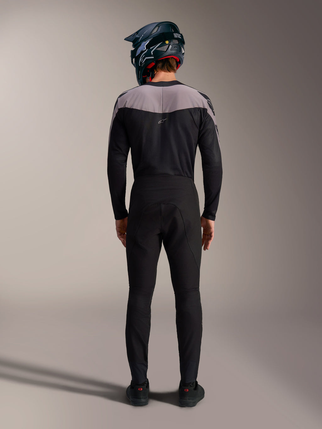 Kit MTB Alpinestars A-Supra Elite negro con jersey, pantalones técnicos y casco integral, vista posterior.