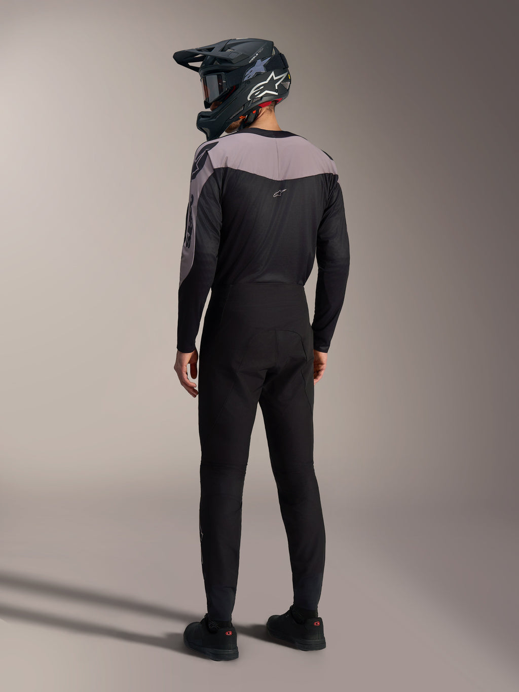 Kit Alpinestars A-Supra Elite MTB negro y gris, jersey de rendimiento y pantalones de carrera vistos desde atrás.