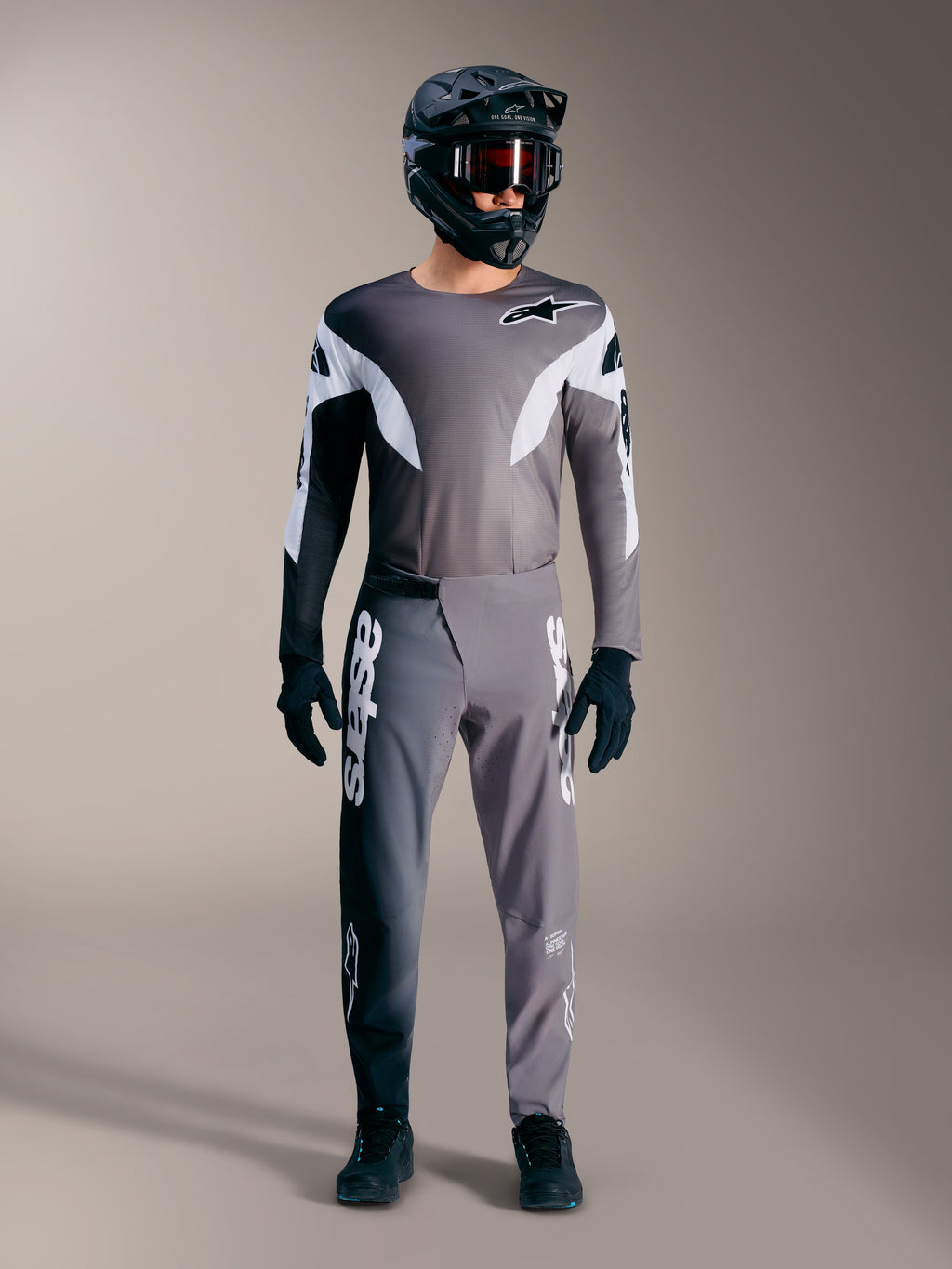 Conjunto MTB Alpinestars A-Supra Elite gris degradado, incluye jersey y pantalones técnicos con grandes logotipos blancos.