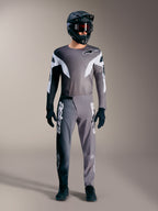 Conjunto MTB Alpinestars A-Supra Elite gris degradado, incluye jersey y pantalones técnicos con grandes logotipos blancos.