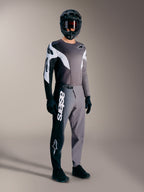 Kit de MTB Alpinestars A-Supra Elite en gris degradado, con pantalones técnicos de logotipo blanco y jersey de competición.