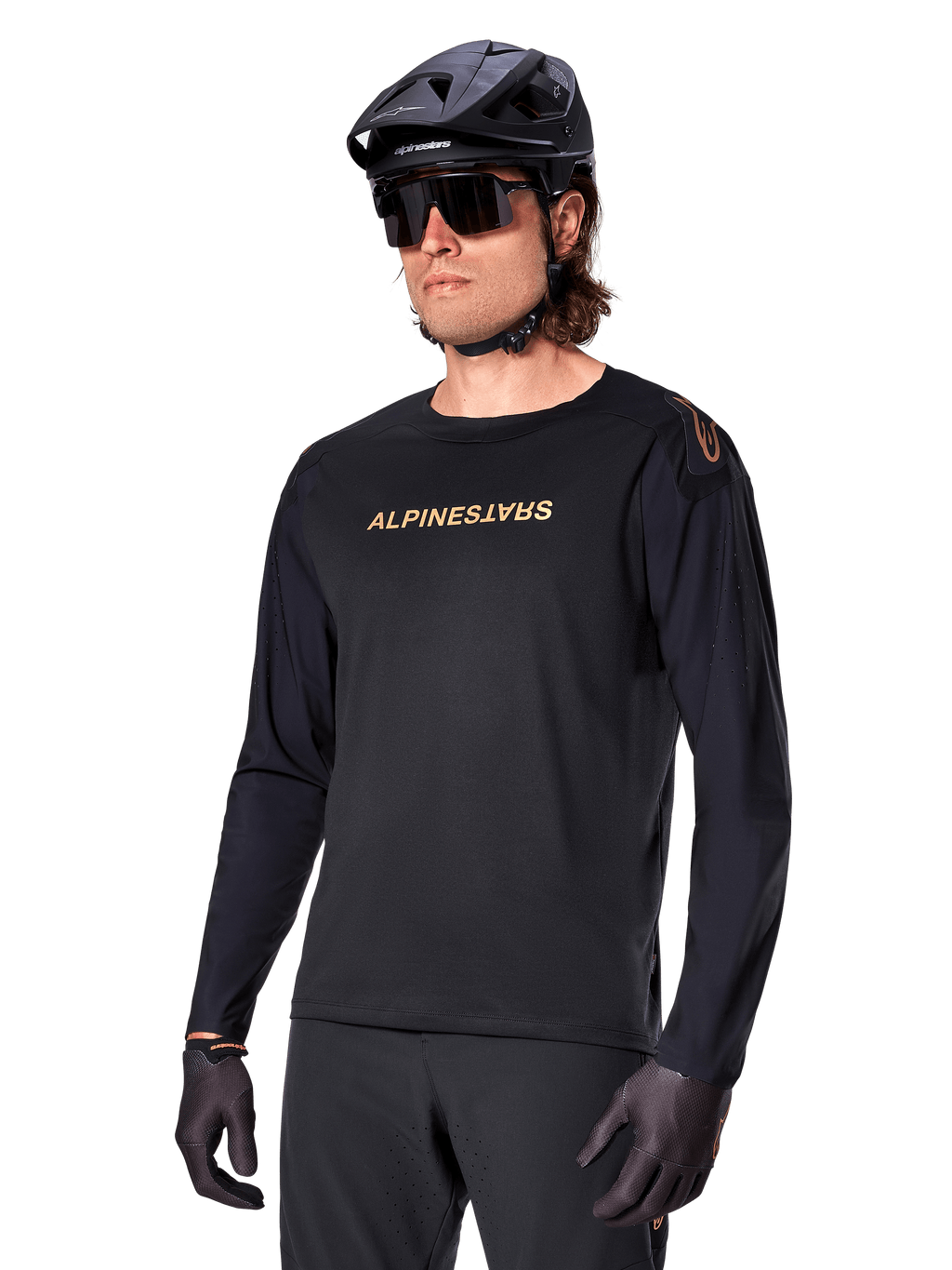 Alpinestars Jersey de manga larga A-Aria Polartec Switch, negro con logotipo dorado, ropa de ciclismo de montaña MTB, usado con casco negro y gafas de sol, con ventilación cortada con láser en las mangas y tejido Polartec que absorbe la humedad para un rendimiento off-road