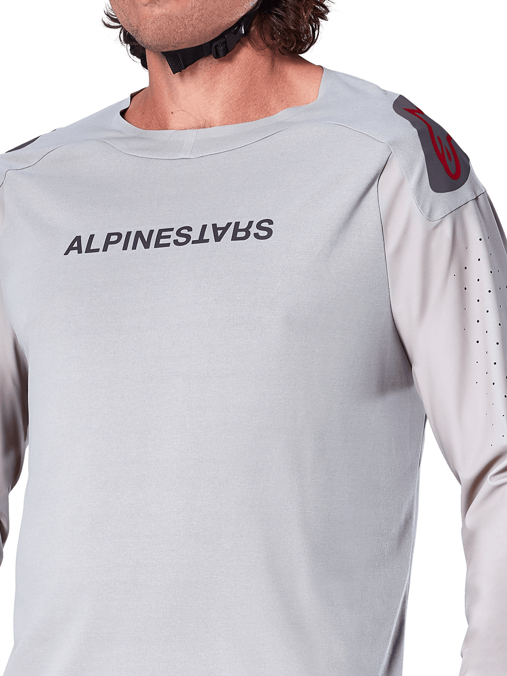 Primer plano del jersey de manga larga Alpinestars A-Aria Polartec Switch en gris claro, con logotipo de Alpinestars en el pecho, logo rojo en el hombro y mangas con perforaciones láser para el flujo de aire, equipamiento premium para ciclismo de montaña