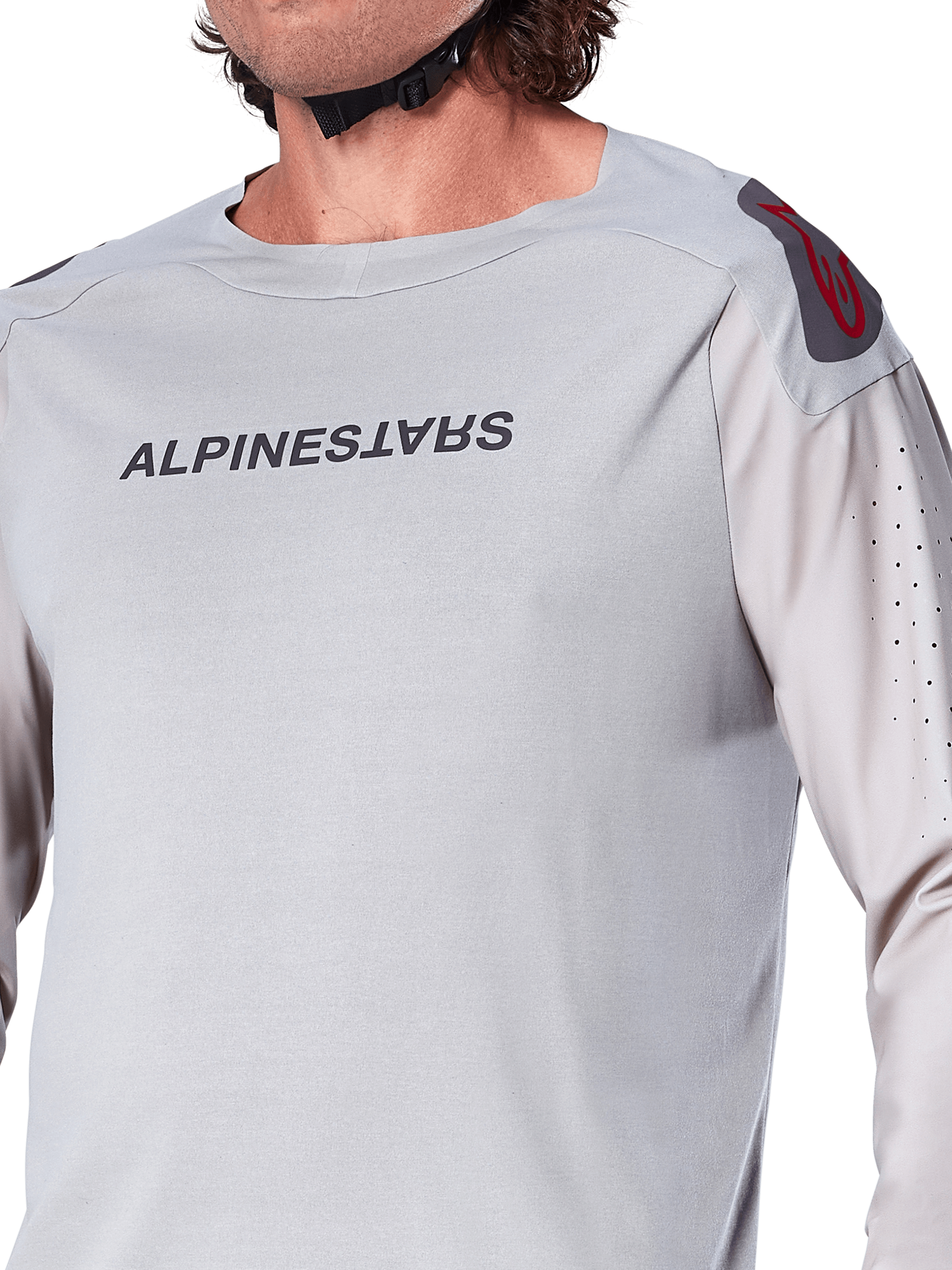Primer plano del jersey de manga larga Alpinestars A-Aria Polartec Switch en gris claro, con logotipo de Alpinestars en el pecho, logo rojo en el hombro y mangas con perforaciones láser para el flujo de aire, equipamiento premium para ciclismo de montaña