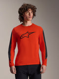 Alpinestars Jersey A-Dura Insert Astar - Manga Larga, naranja Spicy con logo Astar negro, con inserciones duraderas gris oscuro en las mangas, usado por un modelo masculino, ropa de ciclismo MTB de alto rendimiento