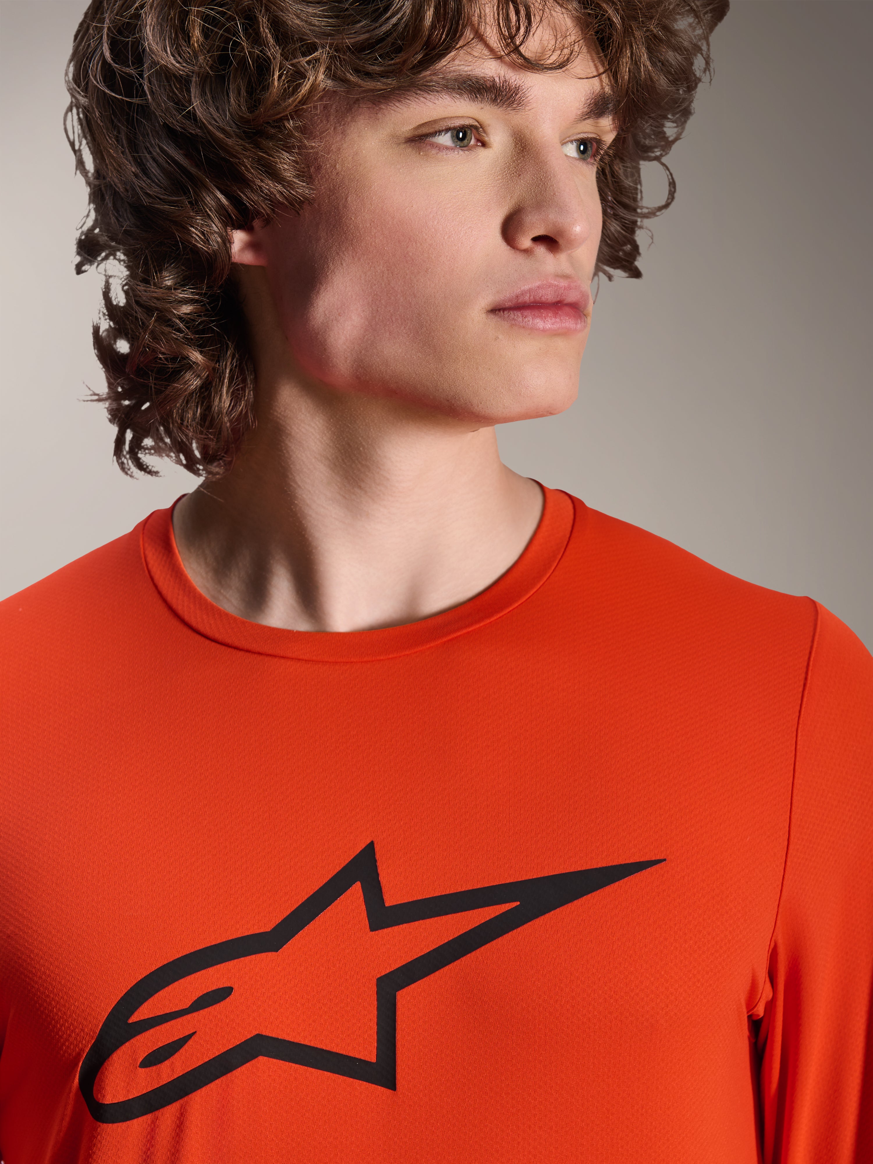 Jersey Alpinestars A-Dura Insert Astar, jersey de MTB de manga larga, color Spicy Orange, con el logotipo Alpinestars Astar negro en el pecho, primer plano de un modelo masculino