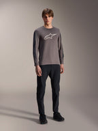 Jersey Alpinestars A-Dura Insert Astar, jersey de MTB de manga larga, gris oscuro, con un gran logotipo blanco en el pecho, usado con pantalones técnicos negros y calzado negro, ropa de ciclismo todoterreno