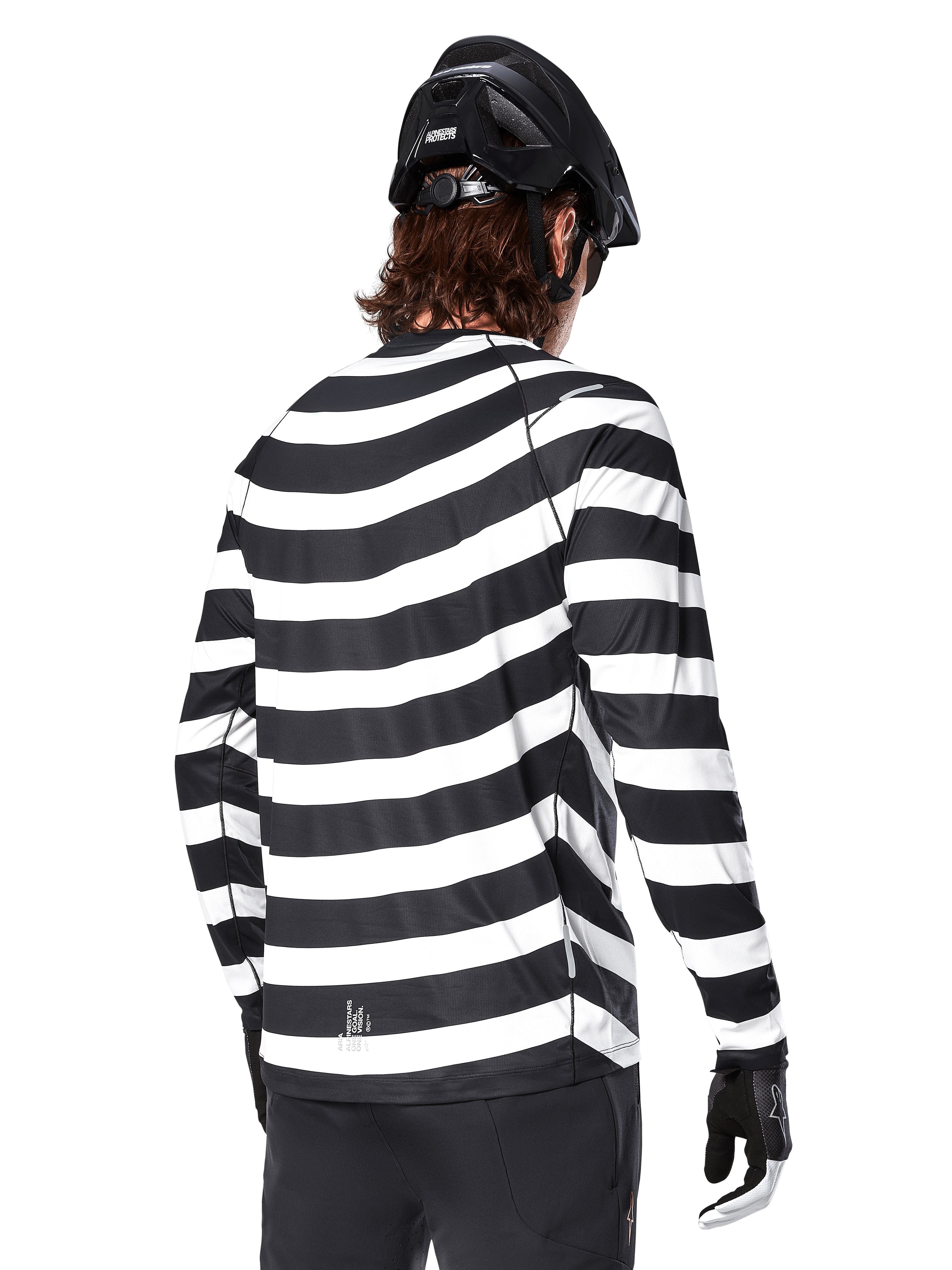 Jersey de manga larga Alpinestars A-Aria Oscar, vista trasera, con llamativas rayas horizontales blancas y negras, combinado con un casco de MTB negro y pantalones negros, equipamiento de alto rendimiento para MTB inspirado en el legado de la marca