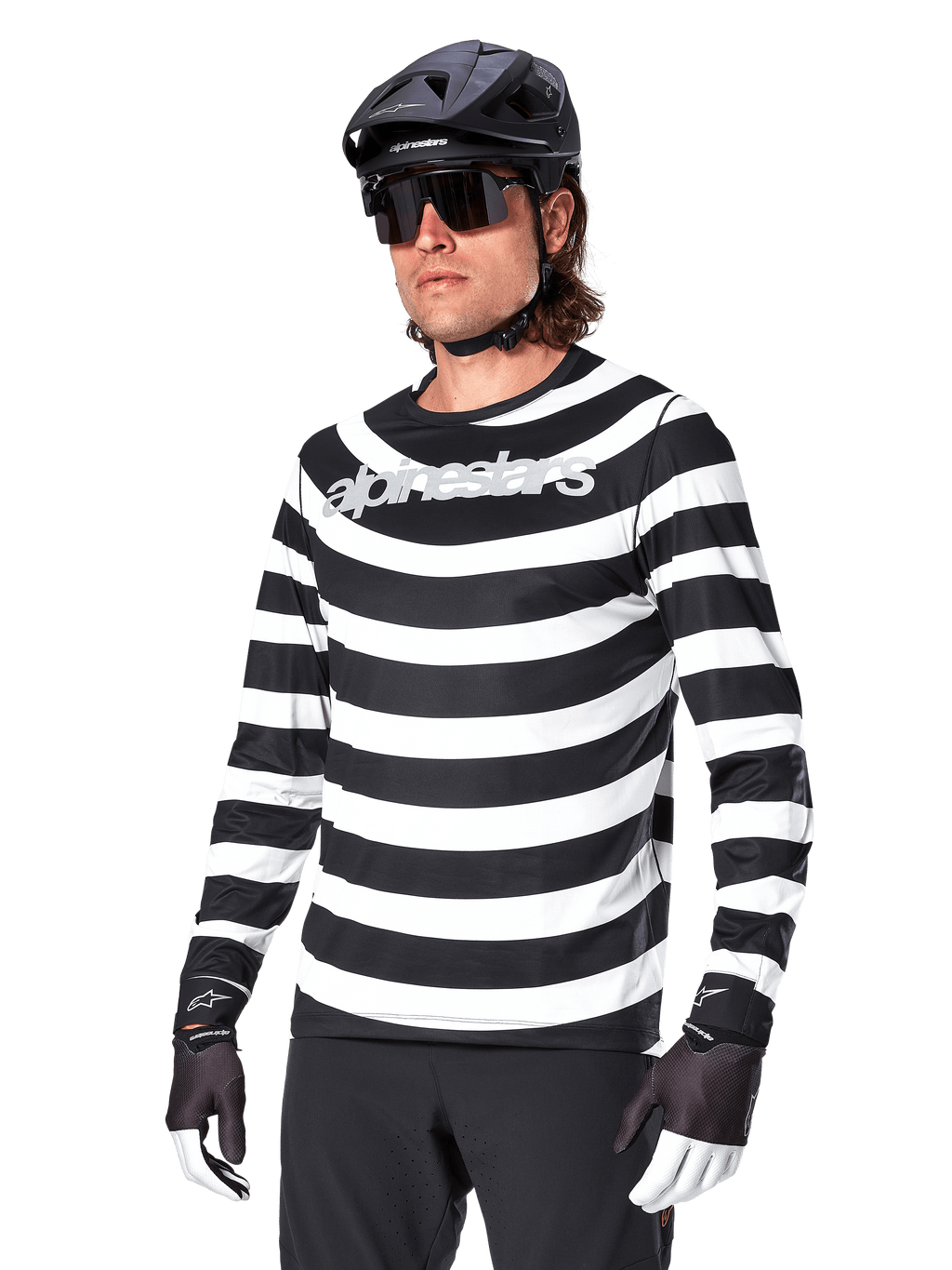 Alpinestars A-Aria Oscar Jersey de manga larga, camiseta de ciclismo MTB, rayas horizontales blancas y negras, usado con un casco negro y gafas de sol, con el logotipo de Alpinestars en el pecho, ropa de alto rendimiento para bicicleta de montaña