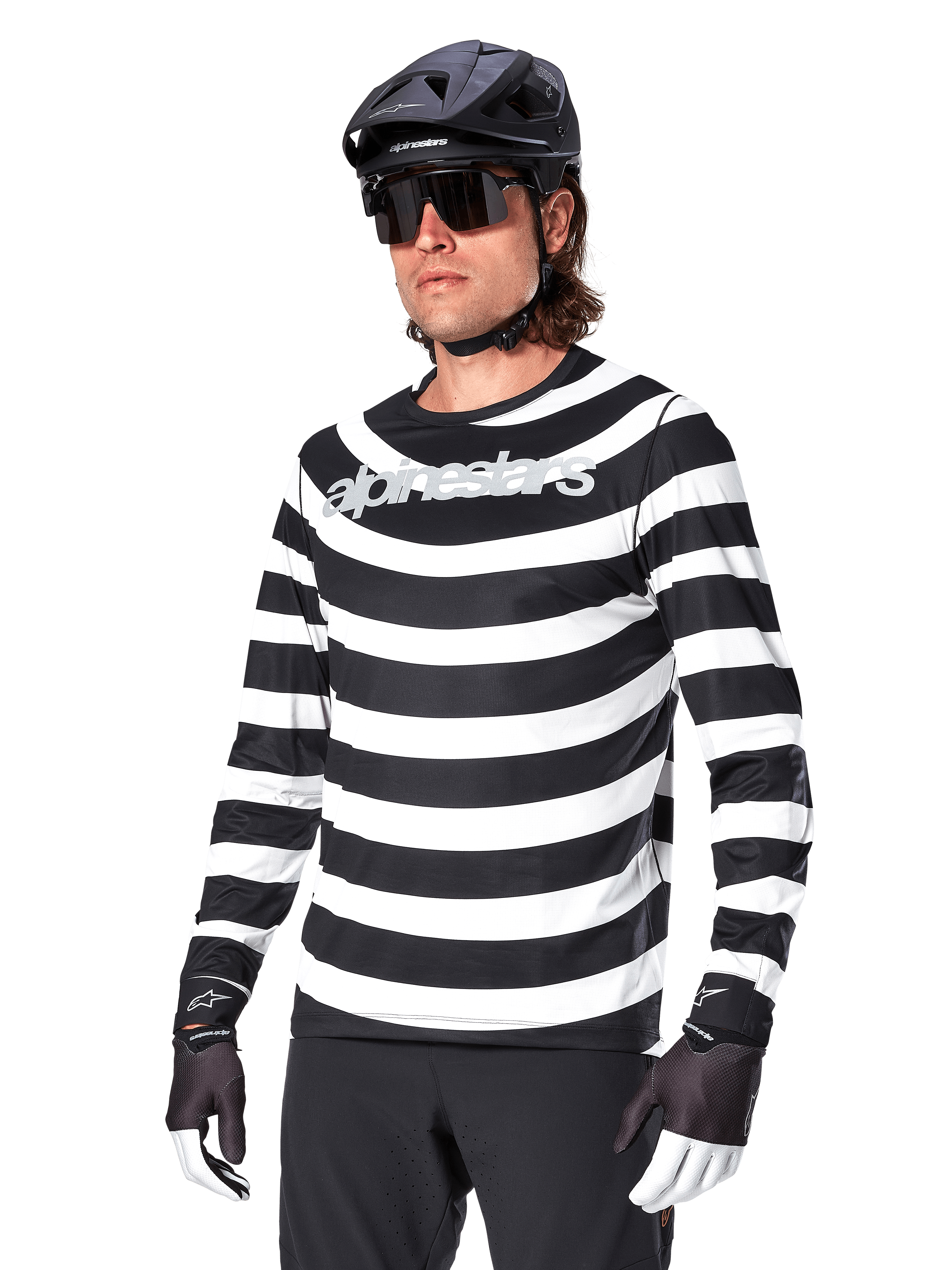 Alpinestars A-Aria Oscar Jersey de manga larga, camiseta de ciclismo MTB, rayas horizontales blancas y negras, usado con un casco negro y gafas de sol, con el logotipo de Alpinestars en el pecho, ropa de alto rendimiento para bicicleta de montaña