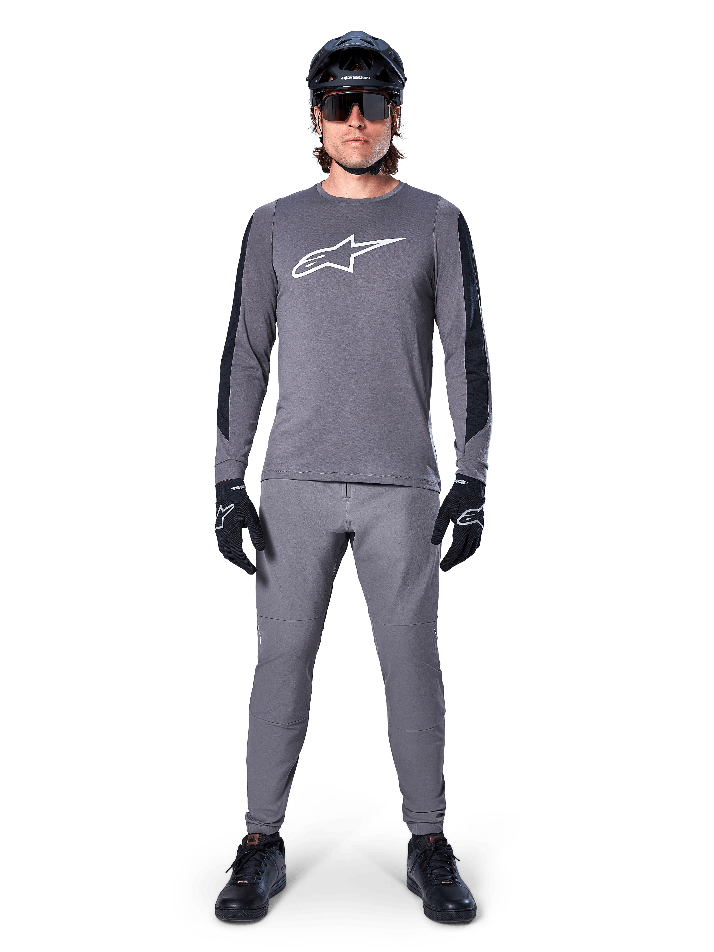 Alpinestars Jersey A-Dura Dri Astar, jersey de MTB de manga larga en gris oscuro, con el logo del pecho en blanco y paneles negros en las mangas, combinado con pantalones grises a juego, casco negro, gafas de sol y guantes para un conjunto completo de ciclismo off-road