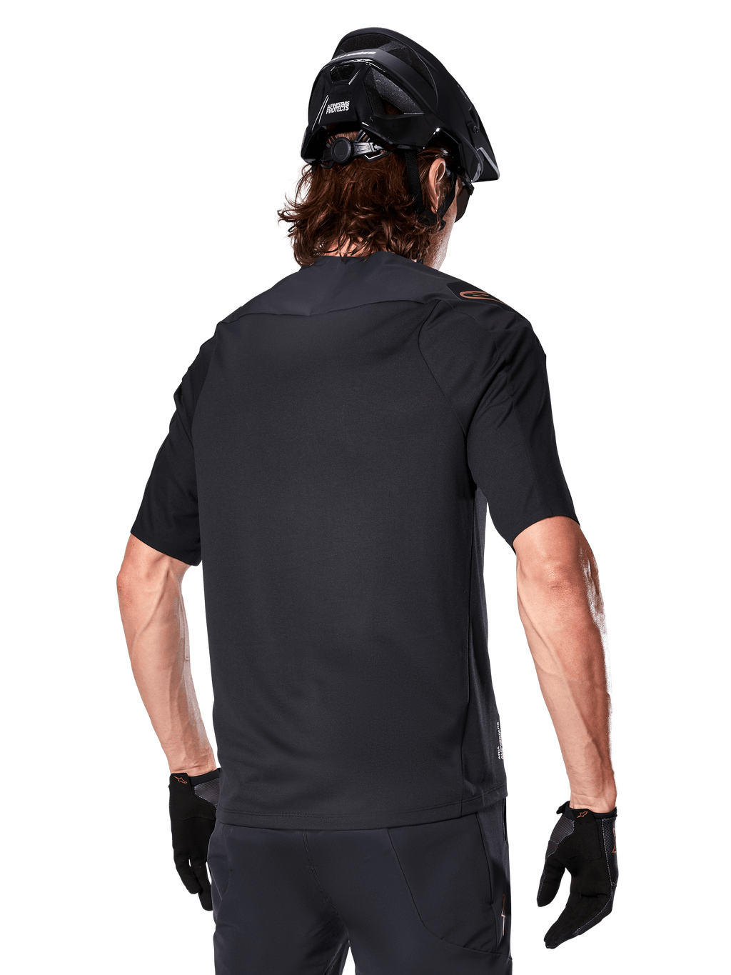 Jersey Alpinestars A-Aria Polartec Switch de manga corta, negro, vista trasera en un ciclista con casco de montaña negro, pantalones cortos y guantes negros a juego, equipamiento de alto rendimiento para ciclismo de montaña