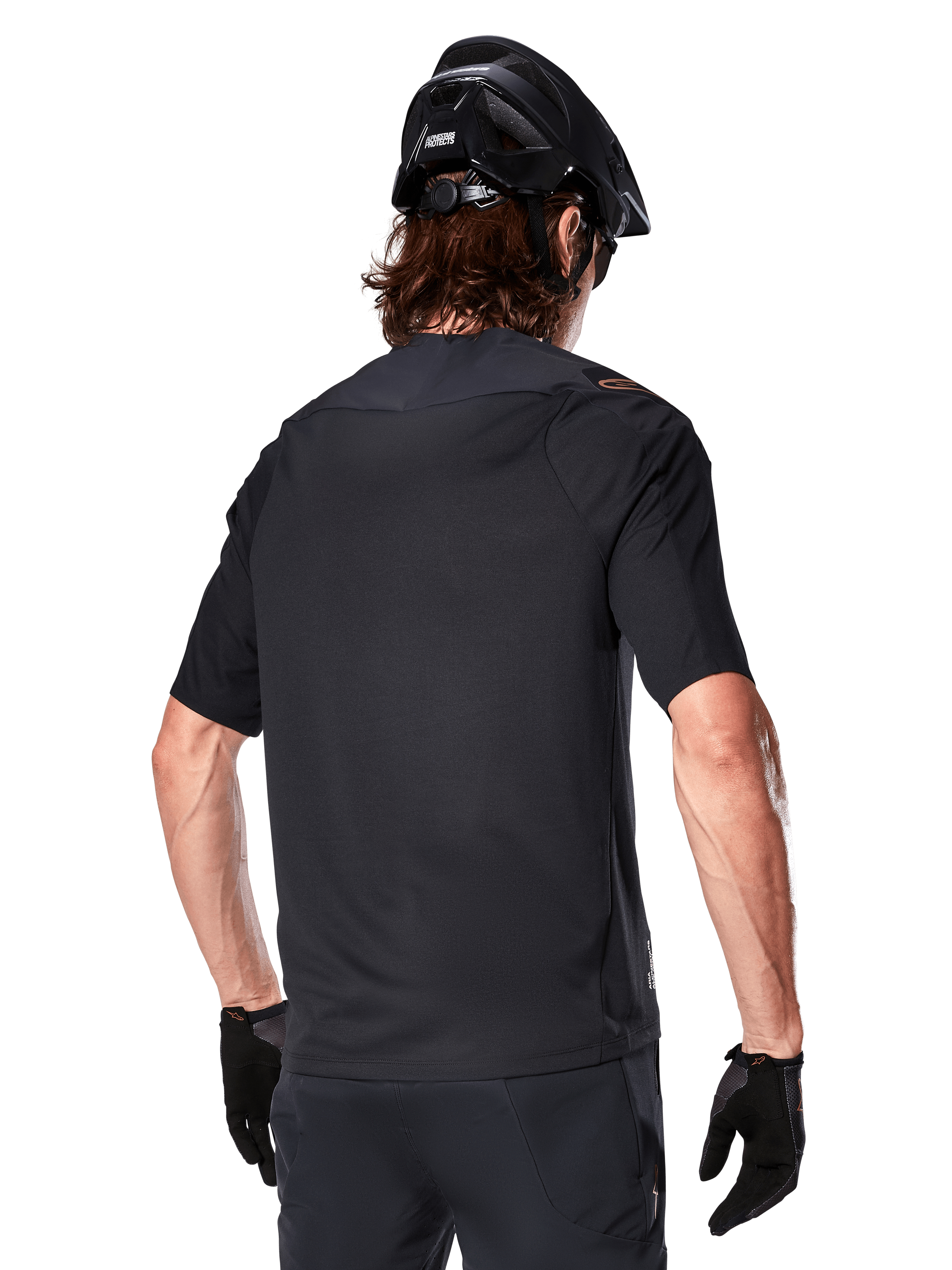 Jersey Alpinestars A-Aria Polartec Switch de manga corta, negro, vista trasera en un ciclista con casco de montaña negro, pantalones cortos y guantes negros a juego, equipamiento de alto rendimiento para ciclismo de montaña