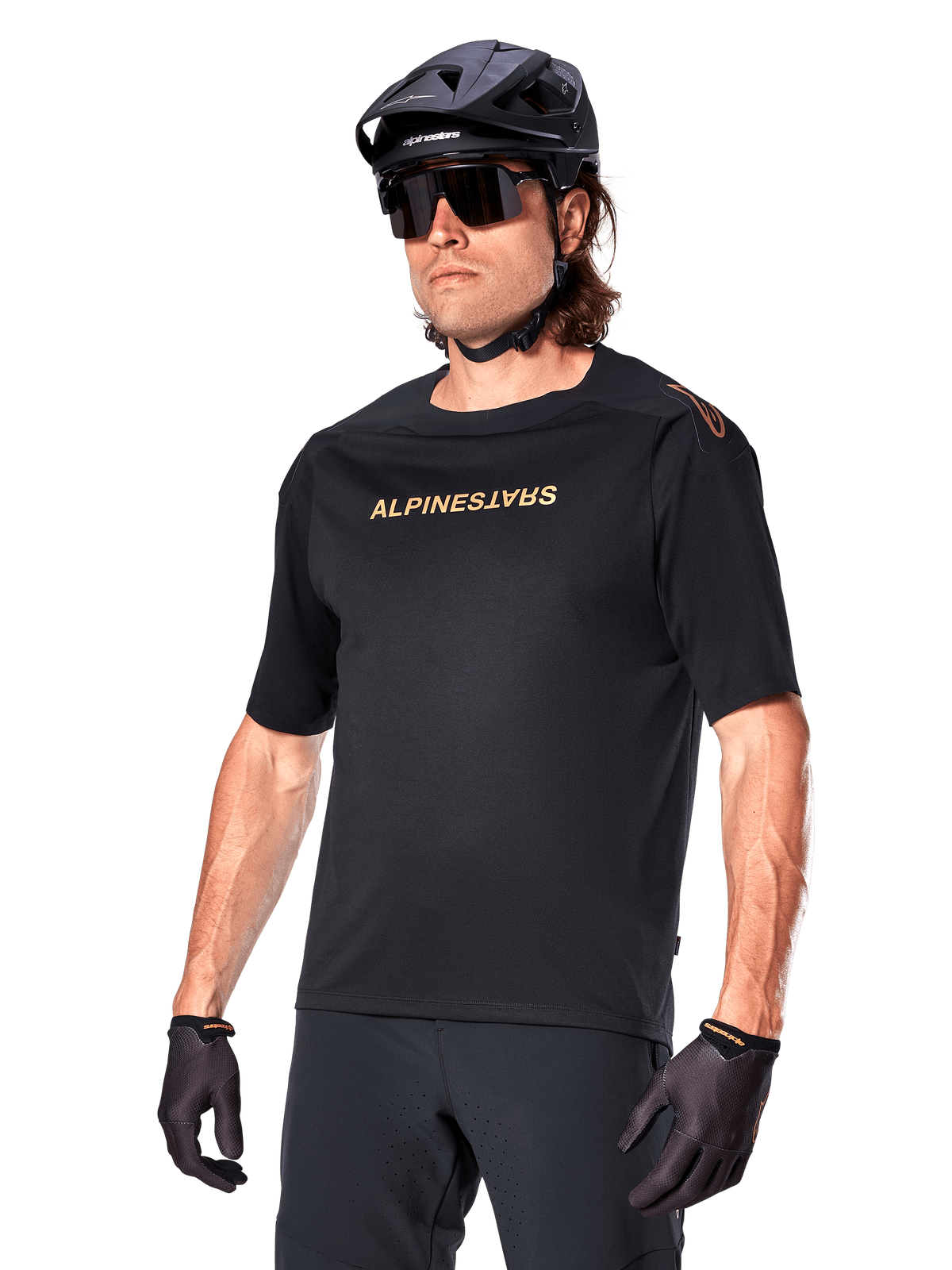 Alpinestars A-Aria Polartec Switch Jersey Short Sleeve, Black mountain bike jersey with gold Alpinestars branding, worn with black helmet, sunglasses, and gloves, technical MTB apparel