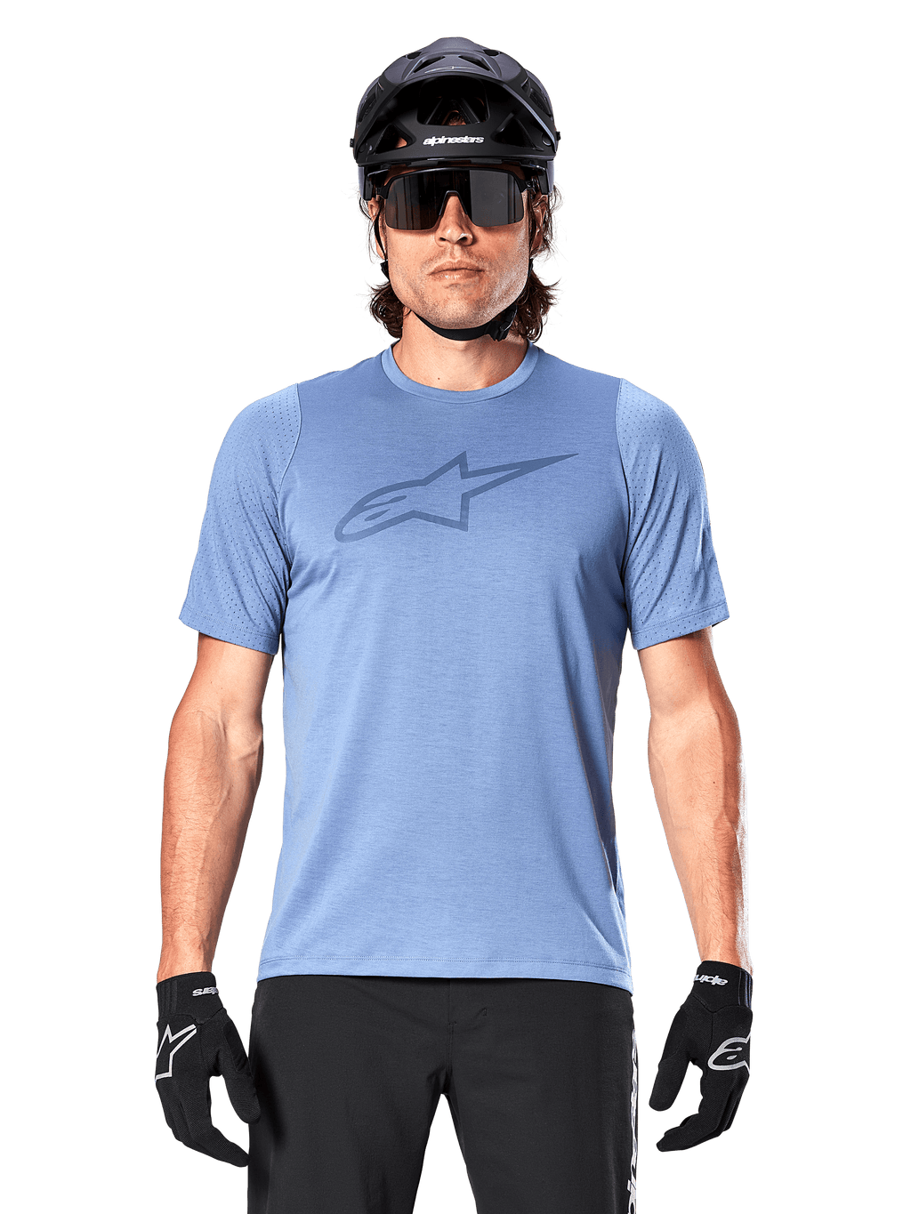 Ciclista de montaña con el jersey de manga corta Alpinestars A-Dura Dri Astar en azul Infinity, con un logotipo sutil en el pecho y paneles de malla, complementado con casco negro, gafas de sol y guantes negros para un conjunto técnico de ciclismo