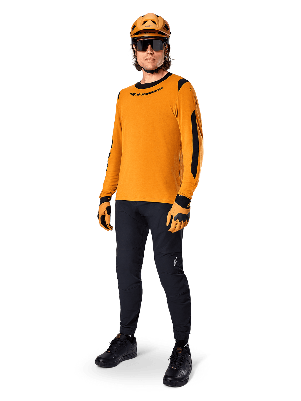 Alpinestars A-Dura Dri Wool Jersey - Long Sleeve, color oro oscuro, combinado con casco naranja a juego, pantalones de MTB negros y guantes amarillos y negros, equipamiento completo de ciclismo para rutas de montaña