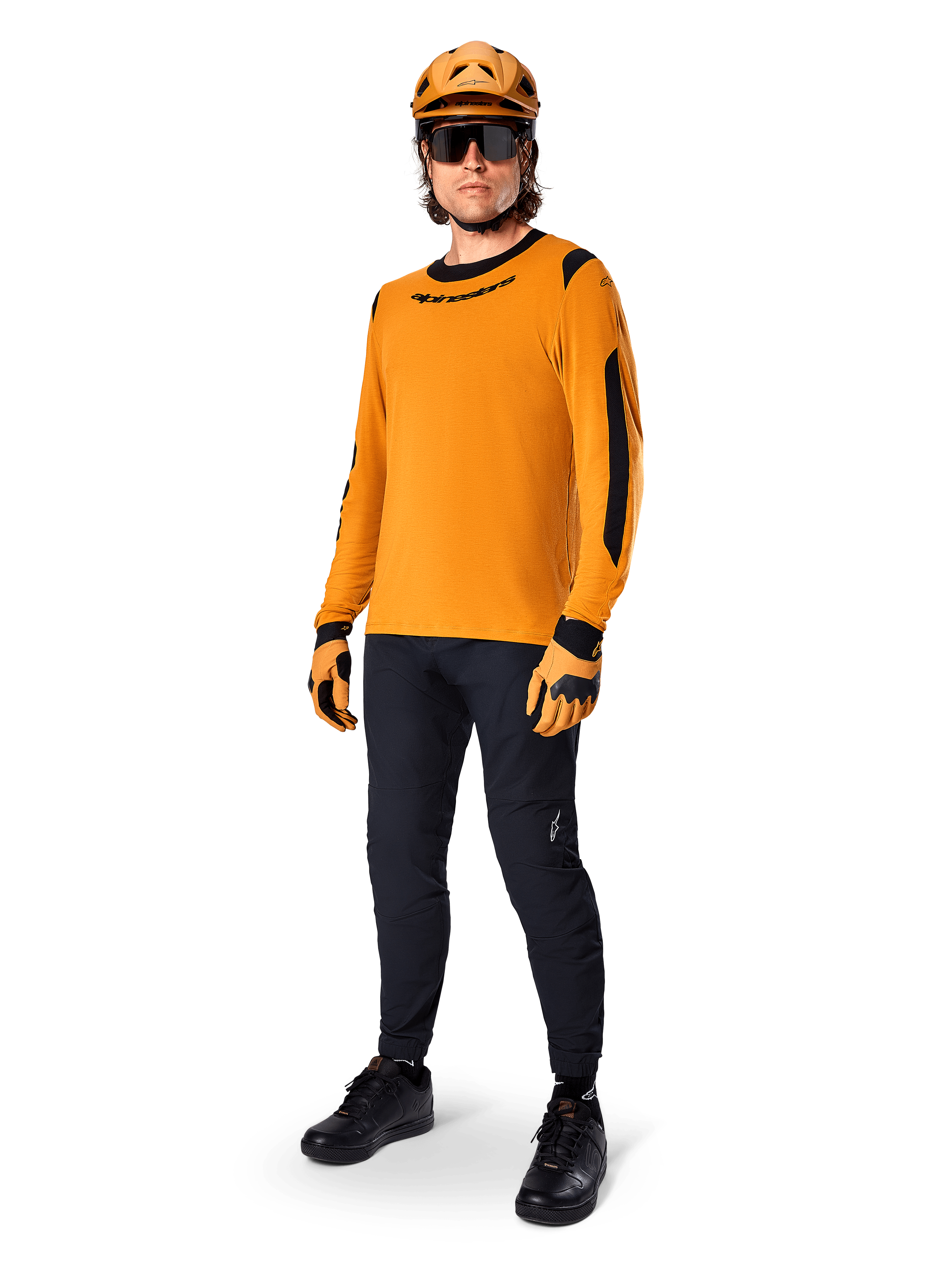 Alpinestars A-Dura Dri Wool Jersey - Long Sleeve, color oro oscuro, combinado con casco naranja a juego, pantalones de MTB negros y guantes amarillos y negros, equipamiento completo de ciclismo para rutas de montaña