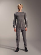 Jersey Alpinestars A-Dura Dri Wool de manga larga, gris oscuro, usado por un modelo con pantalones grises a juego y calzado negro, logotipo de Alpinestars en blanco en el pecho, paneles de malla gris claro en hombros y mangas, equipamiento técnico para bicicleta de montaña