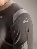 Alpinestars A-Dura Dri Wool Jersey - Manga Larga, gris oscuro, vista detallada del hombro y la manga que muestra paneles de ventilación de malla gris claro y el logotipo blanco de Astars sobre el tejido técnico drirelease.