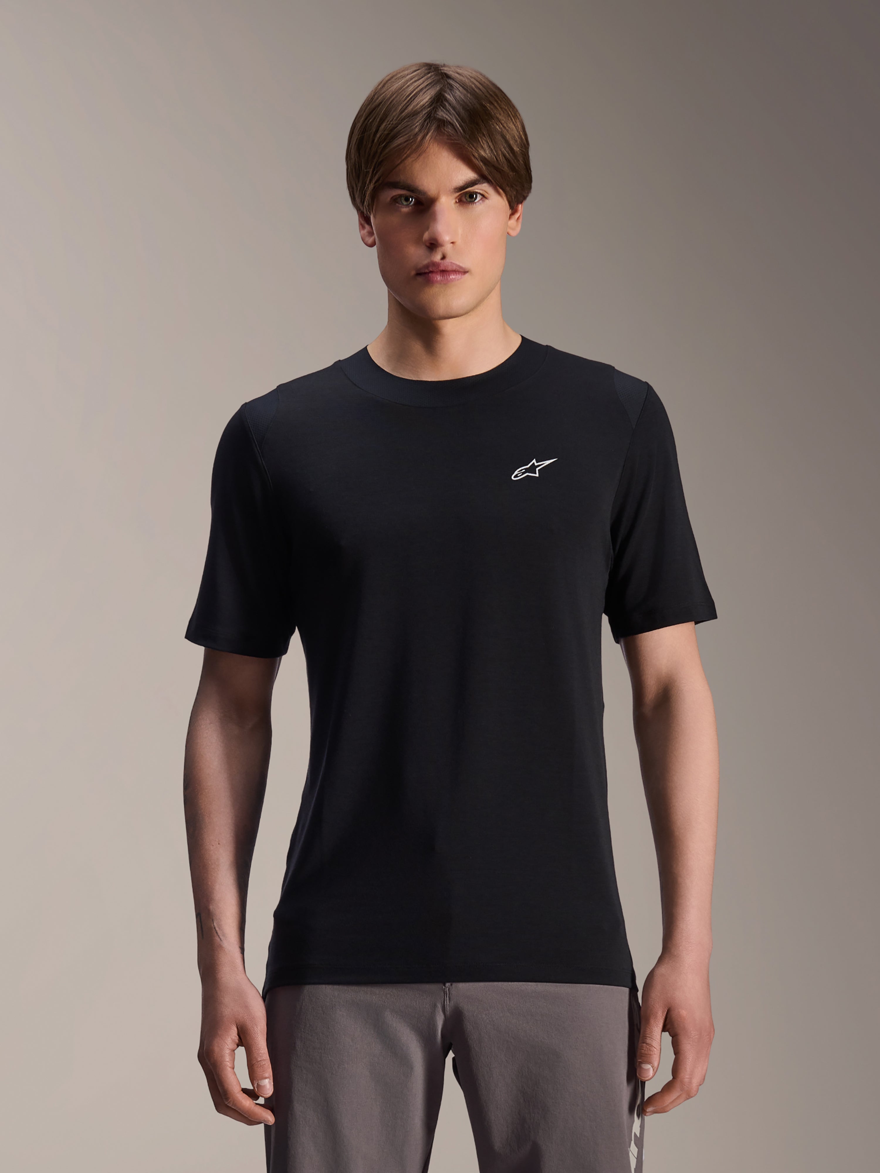 Alpinestars A-Dura Dri Wool Short Sleeve Jersey, negro, usado por modelo masculino, pequeño logo Alpinestars blanco en el pecho, ropa técnica de ciclismo para MTB trail, tejido de lana drirelease que absorbe la humedad