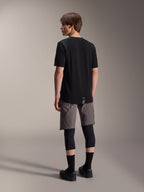 Alpinestars A-Dura Dri Wool Short Sleeve Jersey, negro, vista trasera en modelo, usado con pantalones cortos de ciclismo de montaña grises y rodilleras negras, con dobladillo trasero más largo y un logotipo sutil, ropa técnica de MTB