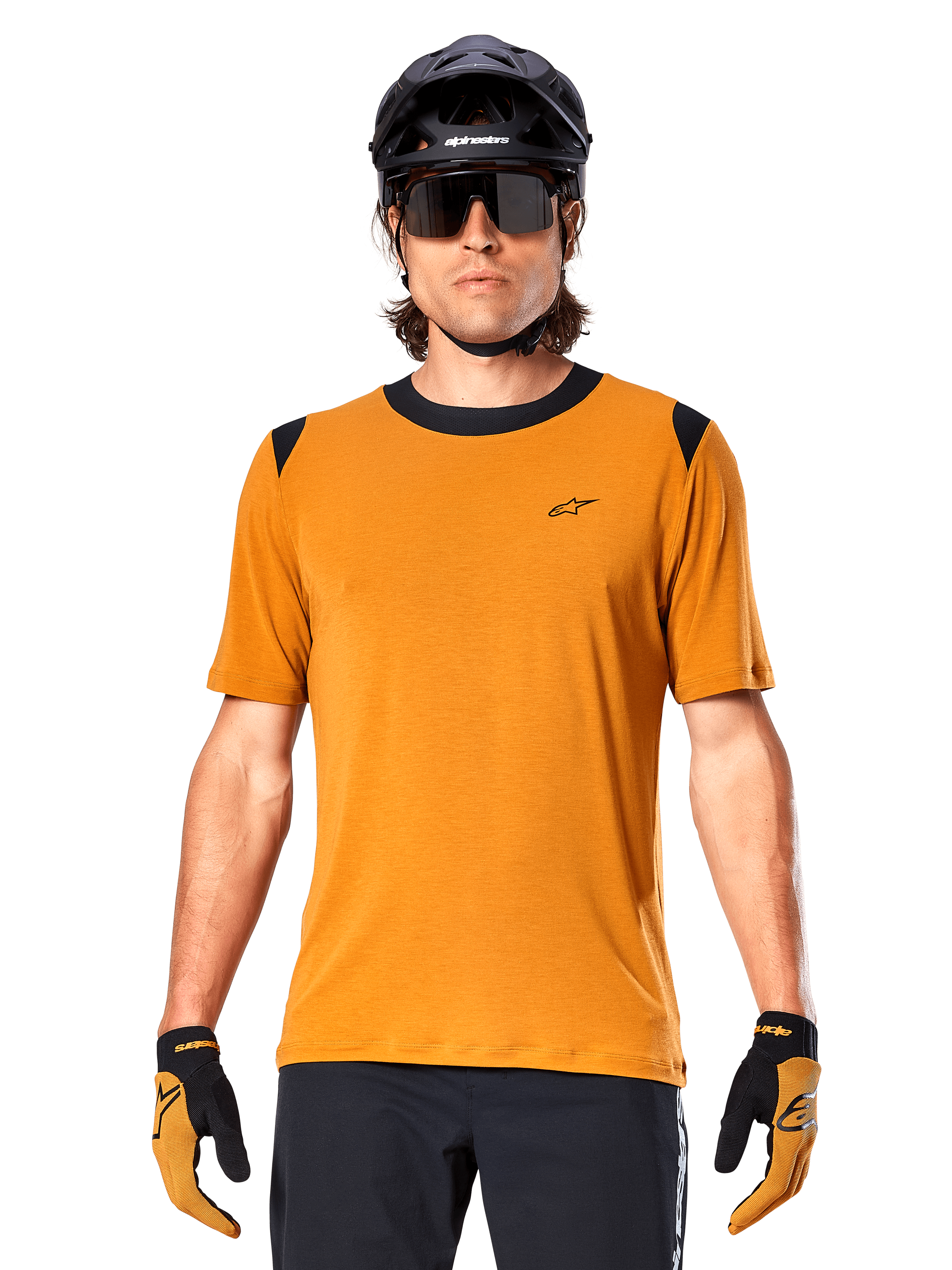 Camiseta de manga corta Alpinestars A-Dura Dri Wool, color oro oscuro, usada con casco de MTB negro, gafas de sol y guantes, con cuello y paneles en los hombros negros, mezcla de lana drirelease transpirable para ciclismo de montaña