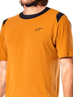 Alpinestars A-Dura Dri Wool Jersey, camiseta de ciclismo de manga corta, oro oscuro, cuello y paneles de los hombros de malla negra, pequeño logo negro en el pecho, vista frontal en primer plano