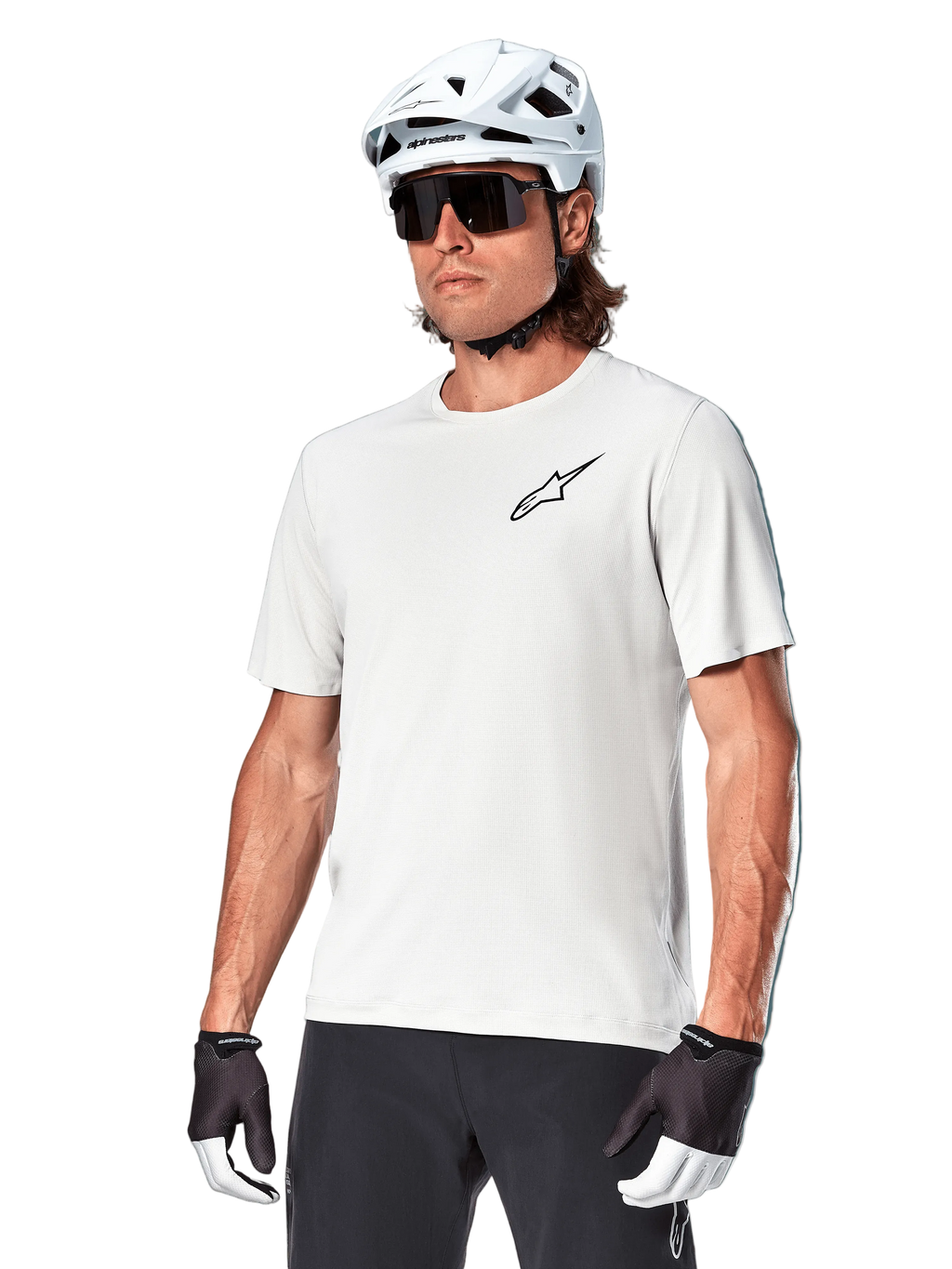 Jersey de manga corta Alpinestars A-Aria Astar, White Dove, usado por un ciclista con casco blanco y gafas de sol oscuras, con un pequeño logotipo de estrella negro en el pecho, equipamiento de alto rendimiento transpirable para ciclismo de montaña
