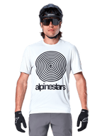 Jersey Alpinestars A-Dura Oscar de manga corta, blanco (White Dove), con un gran gráfico de espiral Oscar vintage en negro y el logotipo de Alpinestars en el pecho, usado por un modelo con casco de MTB negro, gafas de sol y guantes negros, estilo de ciclismo de herencia.