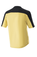 Jersey Alpinestars Drop Meta de manga corta, jersey de ciclismo de montaña, dorado con canesú en los hombros y paneles en las mangas de color negro, vista posterior, parte trasera extendida para mayor cobertura, material de malla ligera.