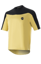 Alpinestars Drop Meta Jersey de manga corta, camiseta de ciclismo MTB, dorada y negra, construcción de malla con hombros en bloques de color, logo circular en el pecho y dobladillo trasero extendido.