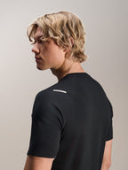 Man wearing Alpinestars A-Aria Switch Jersey, Short Sleeve, Black, view from the side and back showing the performance fit and shoulder detail, lightweight breathable MTB cycling apparel