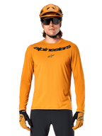 Alpinestars A-Dura Rocker Jersey de manga larga en color Dark Gold, con un logotipo negro en el pecho, combinado con casco y guantes dorados a juego para ciclismo de montaña