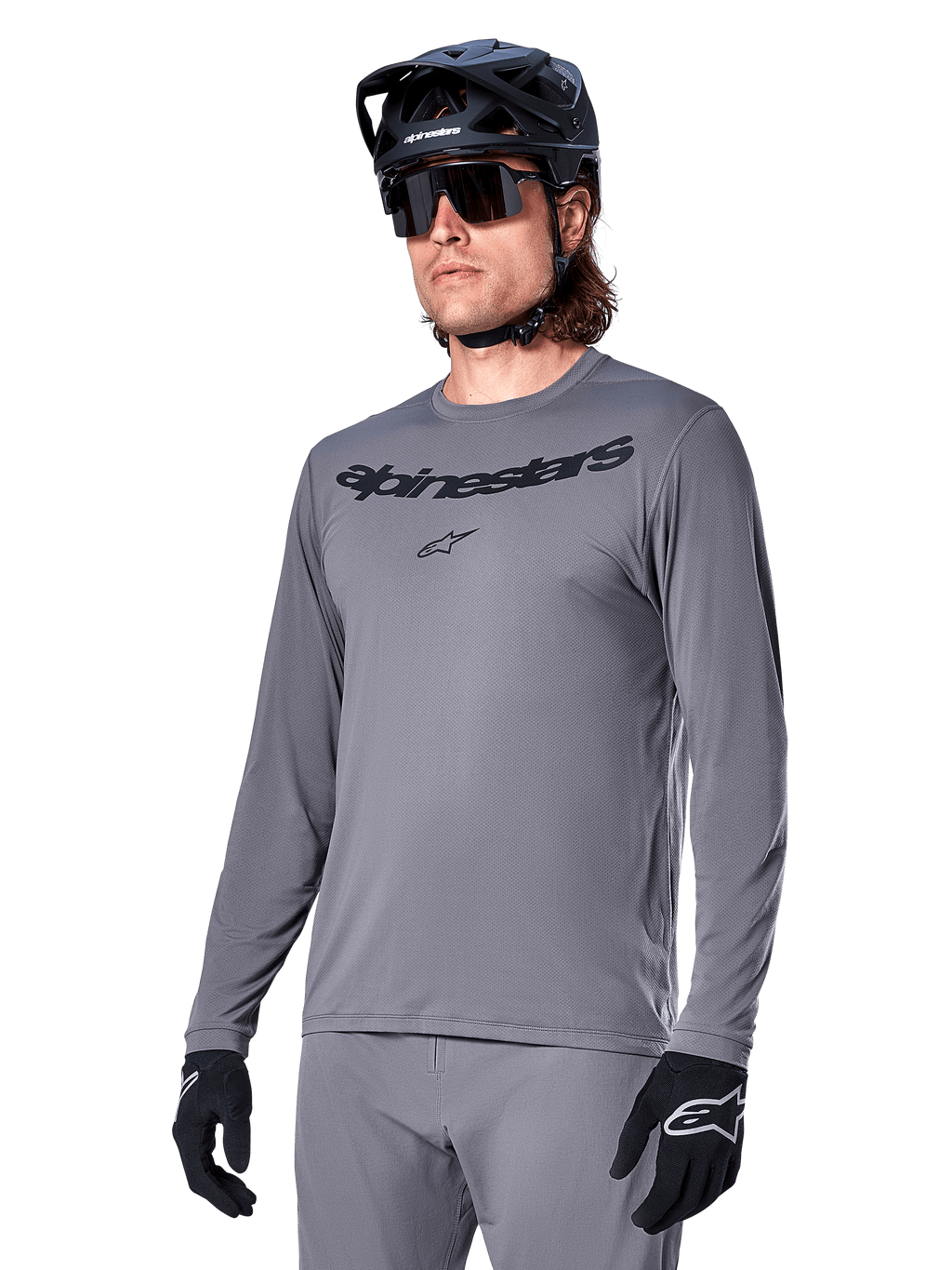 Alpinestars A-Dura Rocker Jersey de manga larga, jersey de MTB gris para ciclismo de montaña, usado con casco y guantes negros, con logotipo negro en el pecho, ropa deportiva de ciclismo para recorridos todoterreno, fondo liso