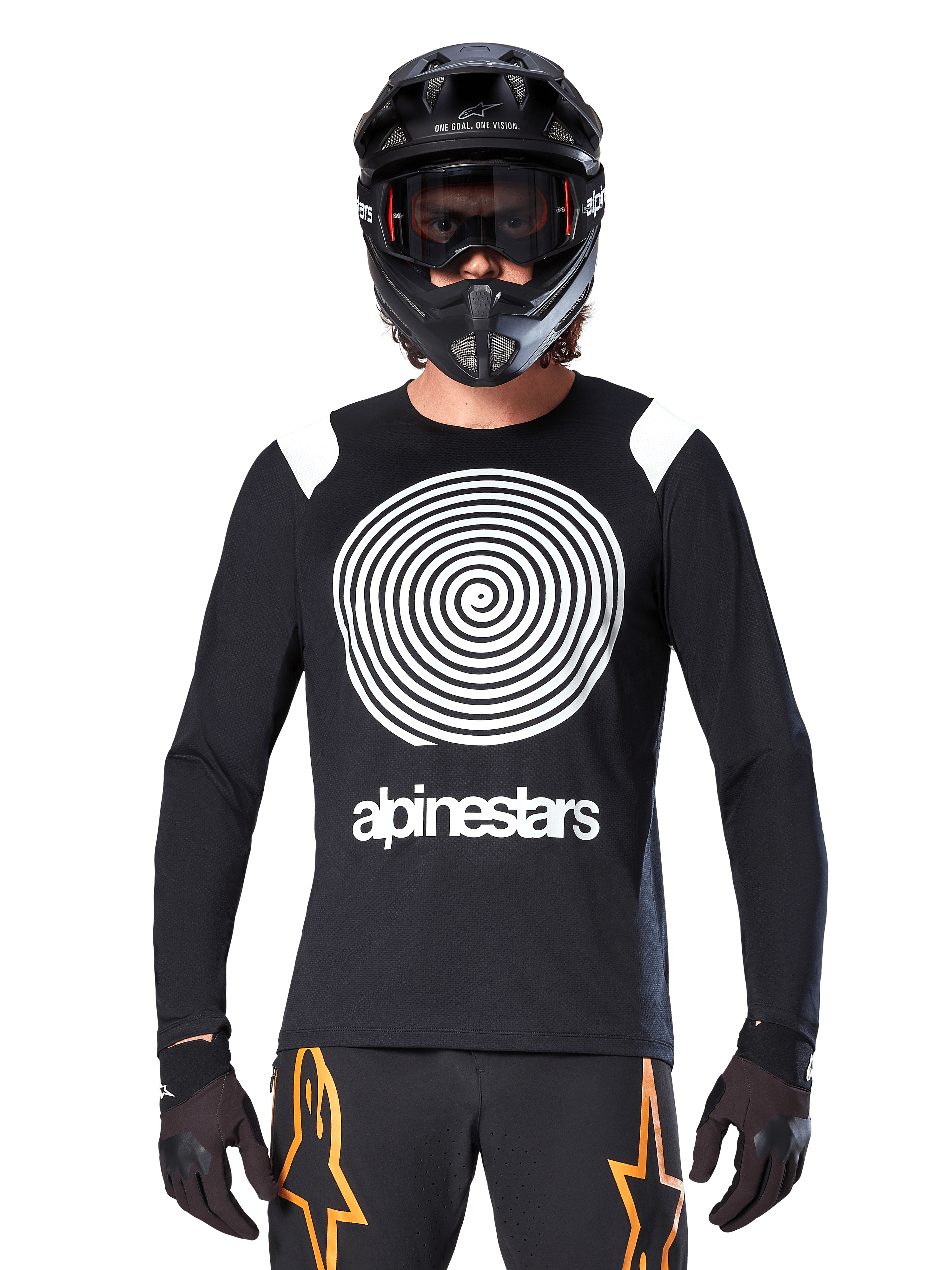 Jersey de manga larga Alpinestars A-Supra Oscar, negro con gráfico en espiral blanco y detalles en los hombros, usado por un ciclista con casco integral negro y gafas, pantalones negros y naranjas, equipamiento técnico de ciclismo para MTB de gravedad