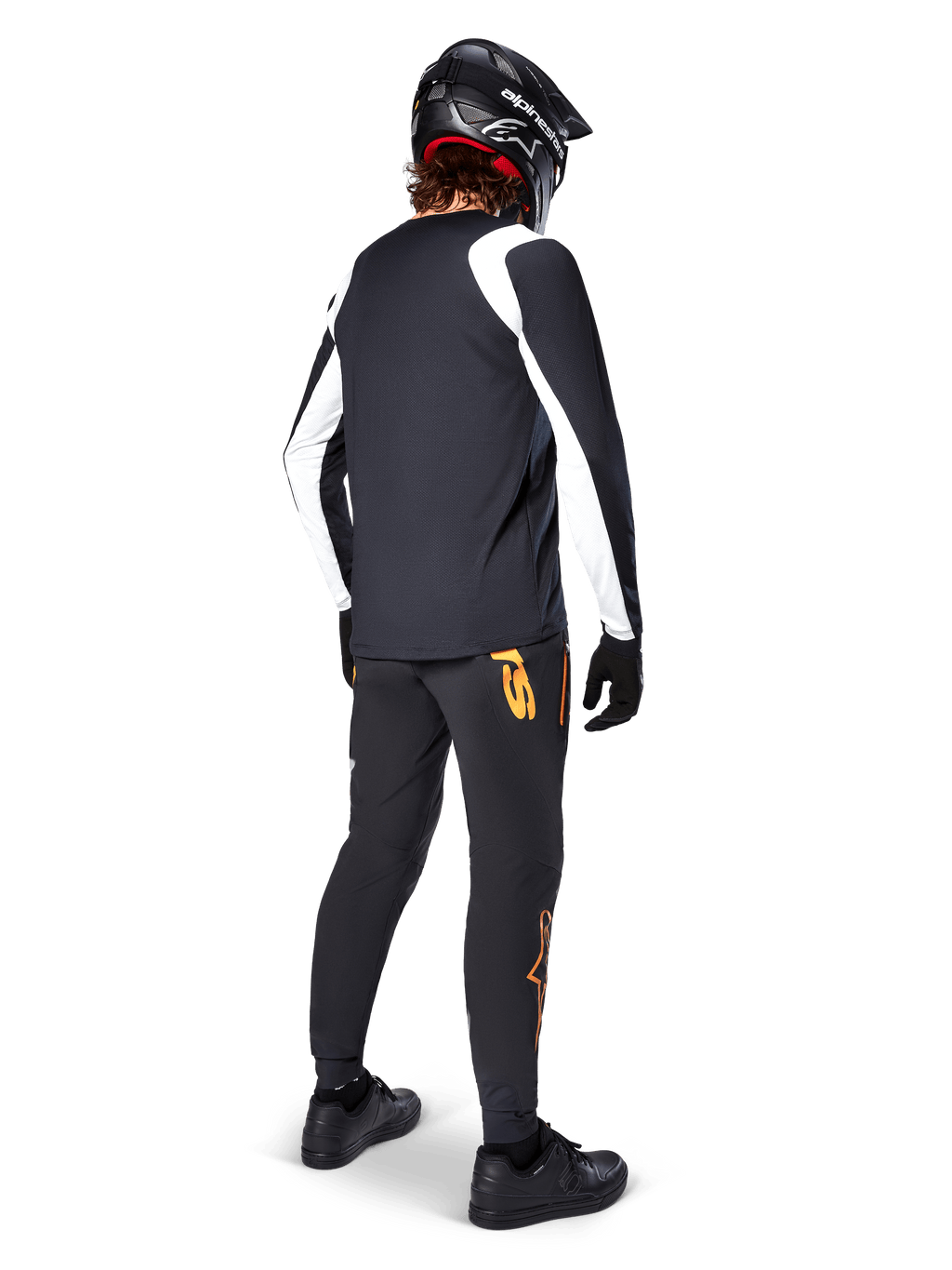 Jersey de manga larga Alpinestars A-Supra Oscar, negro con paneles blancos en las mangas, visto desde atrás en un ciclista de MTB con casco integral negro y pantalones negros con logotipos naranjas, ropa de ciclismo para gravity todoterreno