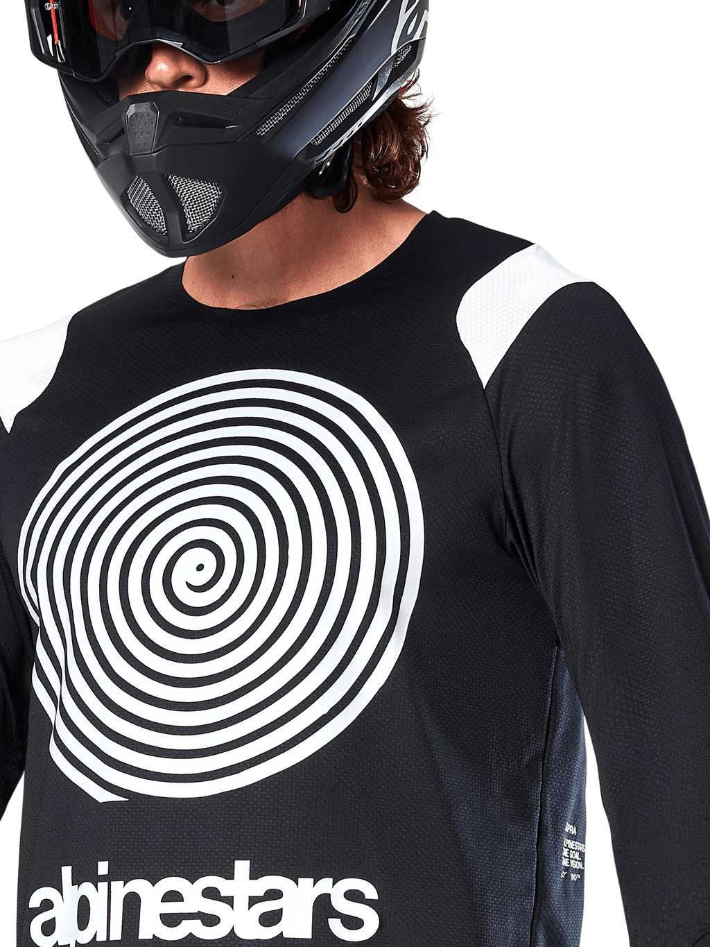Jersey Alpinestars A-Supra Oscar de manga larga, negro, con un gran gráfico espiral Oscar blanco en el pecho y el logotipo de la marca, usado por un ciclista con casco integral negro y gafas, ropa técnica de mountain bike para gravity