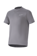 Alpinestars A-Dura Astar Jersey, camiseta de manga corta para ciclismo de montaña, gris oscuro con un pequeño logotipo plateado en el pecho, cuello redondo y parte trasera extendida, tejido técnico transpirable para rutas de MTB
