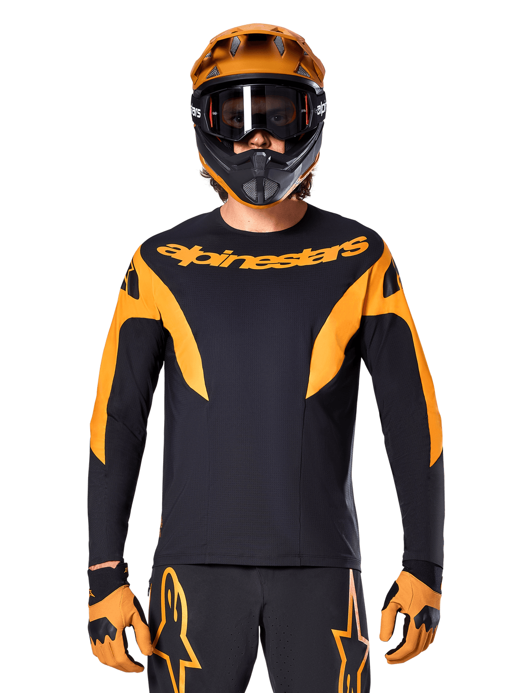 Ciclista de MTB con el jersey Alpinestars A-Supra Race de manga larga, negro con gráficos naranjas y logo en el pecho, combinado con un casco integral naranja a juego, gafas negras y guantes naranjas, kit de carreras coordinado para rendimiento en mountain bike