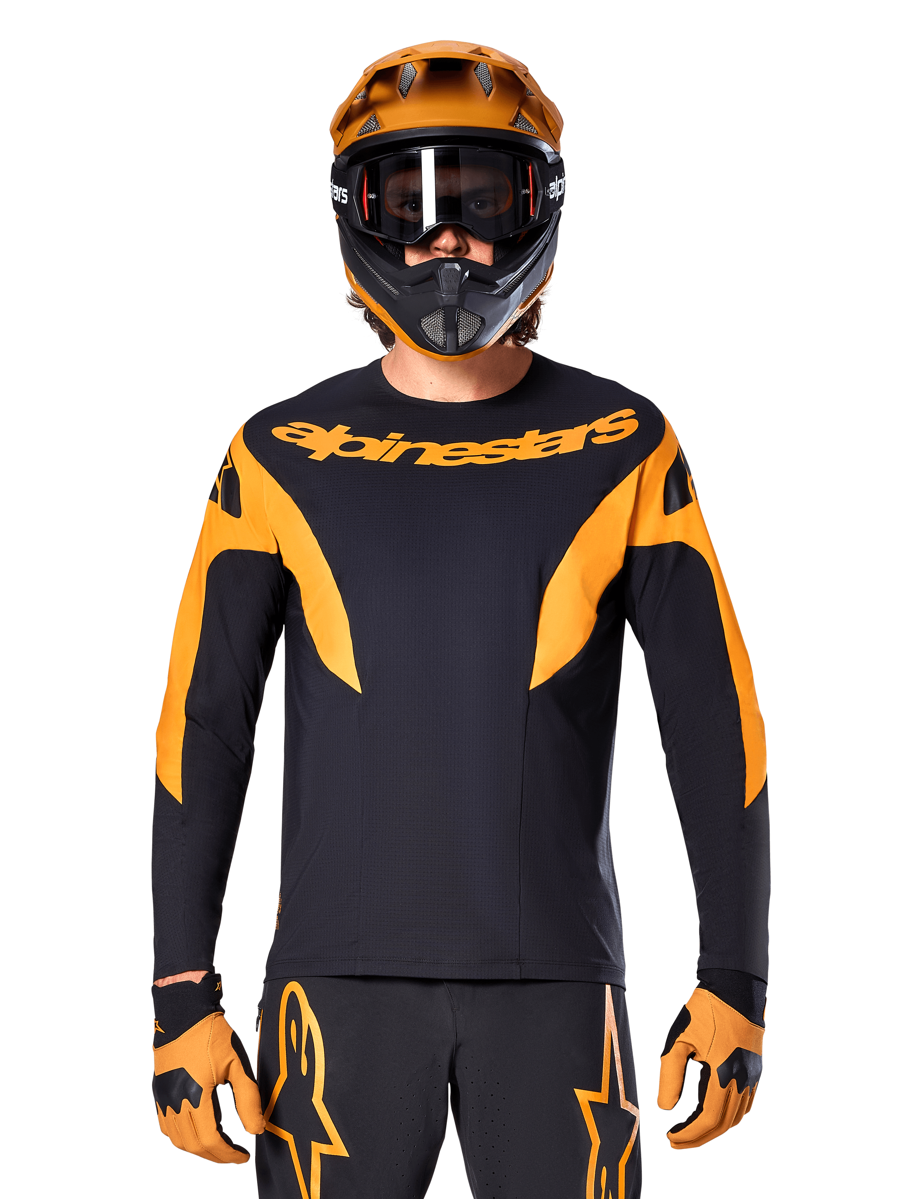 Ciclista de MTB con el jersey Alpinestars A-Supra Race de manga larga, negro con gráficos naranjas y logo en el pecho, combinado con un casco integral naranja a juego, gafas negras y guantes naranjas, kit de carreras coordinado para rendimiento en mountain bike