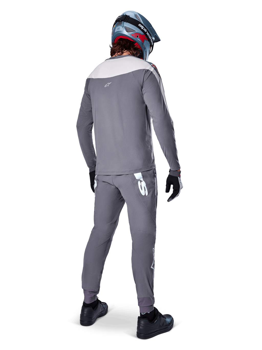 Alpinestars A-Supra Race Jersey, jersey de MTB de manga larga, gris oscuro con panel gris claro en los hombros, vista posterior usado con pantalones a juego, casco integral azul y rojo, guantes y zapatillas negros, equipamiento de ciclismo de alto rendimiento inspirado en la competición