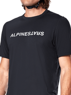 Jersey de manga corta Alpinestars A-Dura Switch, negro, con un gran logotipo de la marca impreso en blanco en el pecho, textura de tejido jacquard de alto rendimiento, primer plano frontal