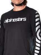 Alpinestars A-Dura Dri Oscar Jersey de Manga Larga, Black Reflective, vista en primer plano que muestra el logotipo blanco de Alpinestars en el pecho y gráficos circulares reflectantes en las mangas, indumentaria técnica de ciclismo para ciclismo de montaña