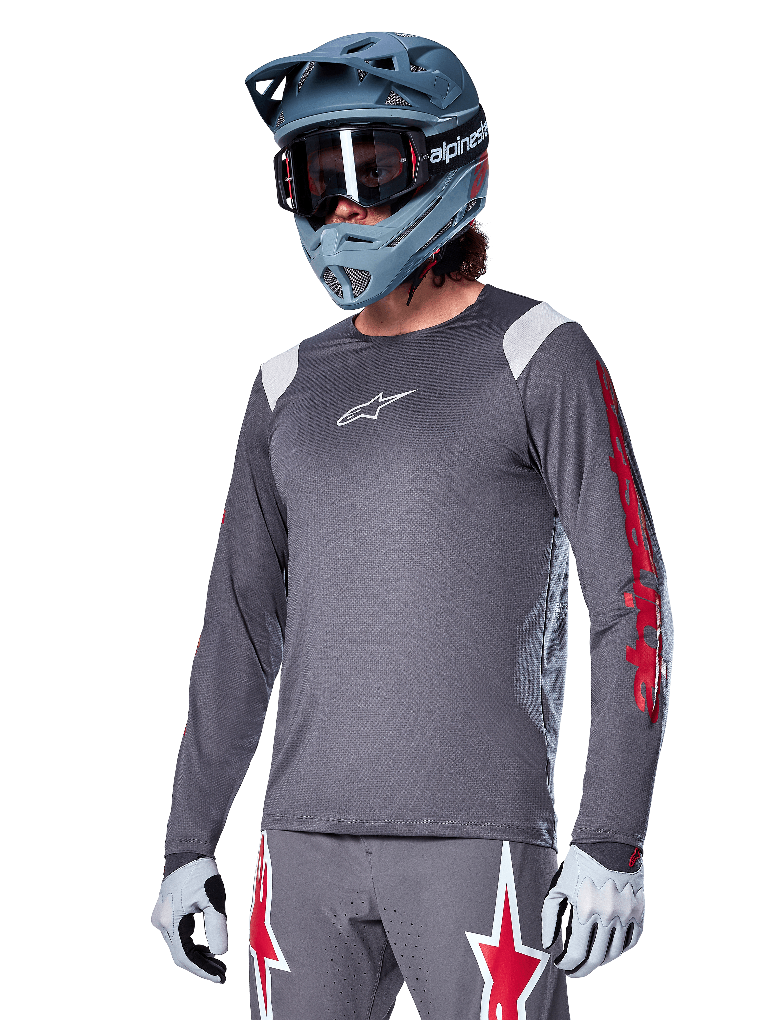 Alpinestars A-Supra Astar Long Sleeve Jersey, MTB Mountain Biking Jersey, Dark Gray with Red and White accents, performance fit, worn with matching gray pants featuring red and white star graphics, complete off-road cycling outfit with full-face helmet and gloves
