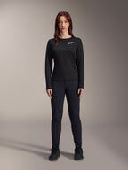 Alpinestars Stella A-Dura Thermal Jersey, jersey de ciclismo de montaña de manga larga para mujer en color negro, con un logotipo blanco en el pecho, combinado con equipamiento negro a juego y zapatillas de ciclismo, retrato de estudio.