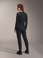 Alpinestars Stella A-Dura Thermal Jersey para mujer, jersey de MTB de manga larga en color negro, vista trasera que muestra detalles reflectantes en los hombros y parte trasera extendida, usado con pantalones y calzado negros, equipamiento de alto rendimiento para ciclismo de montaña.