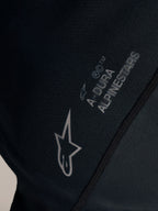Detalle del jersey Stella A-Dura Ride negro con logotipo Alpinestars blanco y marca A-DURA en tejido jacquard.