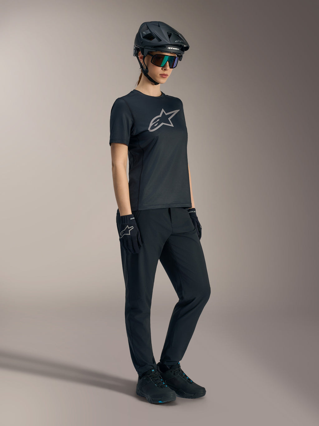 Stella A-Dura Ride Jersey negra, camiseta de MTB de manga corta para mujer con logo plateado de Alpinestars en el pecho.
