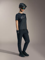 Stella A-Dura Ride Jersey negra, camiseta de MTB de manga corta para mujer con logo plateado de Alpinestars en el pecho.