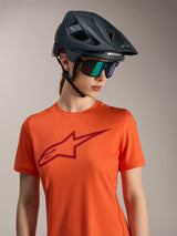 Jersey Alpinestars Stella A-Dura Ride naranja, logotipo rojo, casco de MTB negro y gafas de sol iridiscentes.